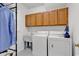 Well-lit laundry room with cabinets, utility sink, washer, and dryer at 8234 Timber Ridge Rd., Conway, SC 29526