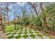 Landscaped backyard showcasing a checkerboard patio, fencing, and lush greenery creating a private outdoor space at 830 Channel Cat Cove, Murrells Inlet, SC 29576