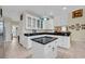 This kitchen features an island, white cabinets, and dark countertops at 830 Channel Cat Cove, Murrells Inlet, SC 29576