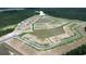 Aerial view of a new home construction site featuring ponds and roadways surrounded by lush trees at 833 Ireland Dr., Longs, SC 29568