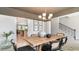 Bright dining room featuring a rustic wooden table, chandelier, and views into the open kitchen at 833 Ireland Dr., Longs, SC 29568