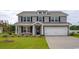 Charming two-story home with gray siding, black shutters, manicured lawn, and an attached two-car garage at 833 Ireland Dr., Longs, SC 29568