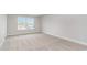 Well-lit bedroom showcasing neutral paint and carpet, and a large window with an outdoor view at 843 Ireland Dr., Longs, SC 29568