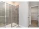 Modern bathroom featuring tiled shower and glass door, next to walk-in closet with ample storage space at 8713 High Banks Way, Longs, SC 29568