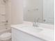 Bright bathroom features a white vanity with a large mirror and tub with shower at 8713 High Banks Way, Longs, SC 29568