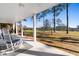 Relaxing covered patio with rocking chair and view of lush green lawn and nearby pond at 904 Easton Ct., Myrtle Beach, SC 29579