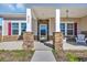 Inviting front porch with stone accents, decorative shutters, and cozy seating at 925 Oak Hollow St., Longs, SC 29568