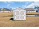 Backyard storage shed with double doors and contrasting trim near a small pond at 925 Oak Hollow St., Longs, SC 29568