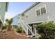 Side view of a coastal home featuring stairs to the front entry and low maintenance landscaping at 1032 N Ocean Blvd., Surfside Beach, SC 29575