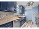 Modern kitchen with stainless steel appliances, a farm sink, stylish backsplash, and custom blue cabinetry at 1032 N Ocean Blvd., Surfside Beach, SC 29575
