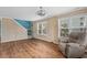 Bright living room with wood floors, paneled walls, two windows, and a comfortable recliner at 1032 N Ocean Blvd., Surfside Beach, SC 29575