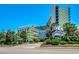 Exterior shot of a resort with lush landscaping, palm trees, and a clear blue sky, creating a tropical paradise at 1105 S Ocean Blvd. # 732, Myrtle Beach, SC 29577
