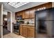This cozy kitchen includes a black refrigerator, oven, and microwave, with wood cabinets for a simple cooking setup at 1105 S Ocean Blvd. # 732, Myrtle Beach, SC 29577