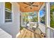 Comfortable covered porch with ceiling fan, outdoor seating, and a view of the surrounding trees at 114 Half Shell Ct., Pawleys Island, SC 29585