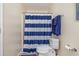 Bathroom highlights a blue striped shower curtain and updated toilet, designed for comfort and style at 1250 River Oaks Dr. # 16B, Myrtle Beach, SC 29579