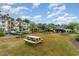 Picnic tables and green space enhance this property and community with mature landscaping and blue skies at 1250 River Oaks Dr. # 16B, Myrtle Beach, SC 29579