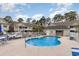 Inviting community pool surrounded by lounge chairs, well-maintained landscaping, and residential buildings at 130 Lazy Willow Ln. # 204, Myrtle Beach, SC 29588