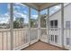 Relaxing screened porch with white railing offering views of the backyard and mature trees at 130 Lazy Willow Ln. # 204, Myrtle Beach, SC 29588