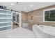 Elegant bathroom with marble floors, a soaking tub and separate shower, plus a view to the adjacent bedroom at 145 Bendick Ct., Little River, SC 29566