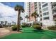 Beautiful Condo building exterior with green common area and tropical palm trees at 1605 S Ocean Blvd. # 509, Myrtle Beach, SC 29577