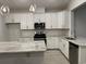 Modern kitchen featuring white cabinets, granite countertops, stainless appliances, and pendant lighting over the island at 174 Glengrove Lane, Murrells Inlet, SC 29576