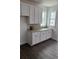 The kitchen counter boasts white cabinets and a patterned backsplash next to bright windows at 175 Glengrove Lane, Murrells Inlet, SC 29576