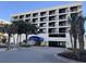 Exterior view of the Sand Dunes Villas building, with a covered entrance and parking garage at 201 N 74Th Ave. N # 2322, Myrtle Beach, SC 29572