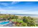 Expansive aerial view of a beach with an ocean pier, pool, and manicured lawn at 2106 N Ocean Blvd. # 410, Myrtle Beach, SC 29572
