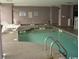 Indoor pool area with a pool, hot tub, lounge chairs, and multiple warning signs at 2106 N Ocean Blvd. # 410, Myrtle Beach, SC 29572