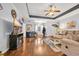 Spacious living room with hardwood floors, comfortable seating, tray ceiling, and decorative fireplace at 224 Cupola Dr., Longs, SC 29568