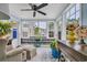 Cozy sunroom with large windows, comfortable seating, ceiling fan and wood paneled walls at 224 Cupola Dr., Longs, SC 29568