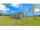 A sturdy metal barn sits in a lush green field under a bright blue sky with fluffy clouds at 2360 Highway 701 North, Loris, SC 29569