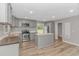 Bright kitchen with gray cabinets, stainless steel appliances, and a kitchen island at 2360 Highway 701 North, Loris, SC 29569