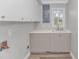 A utility sink and white cabinets are featured in this laundry room at 2360 Highway 701 North, Loris, SC 29569