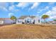 Back exterior with an outdoor seating area, palm trees, and well-maintained yard at 2385 Windmill Way, Myrtle Beach, SC 29579