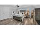 Comfortable bedroom features a large bed, a stylish chandelier and wood-look flooring at 2385 Windmill Way, Myrtle Beach, SC 29579