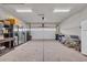 Spacious garage with a white garage door, multiple refrigerators, and storage space at 2385 Windmill Way, Myrtle Beach, SC 29579