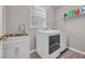 Well-lit laundry room featuring new white washer and dryer units and a stainless steel sink at 2385 Windmill Way, Myrtle Beach, SC 29579