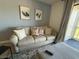 Cozy living room featuring a comfortable sofa, throw pillows, modern artwork, and view to the exterior at 3700 Golf Colony Dr. # 26G, Little River, SC 29566