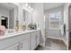 Bright bathroom featuring a double sink vanity with white cabinets and marble countertop plus shower with tile surround at 414 Antietam Place, Little River, SC 29566