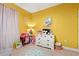 A cute bedroom with yellow walls, light neutral carpet, sheer curtains and lots of toys at 414 Antietam Place, Little River, SC 29566