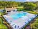 Aerial view of community pool with ample seating, umbrellas, and pool house in a wooded setting at 414 Antietam Place, Little River, SC 29566