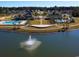 Aerial view showcasing lakefront community amenities with pools, clubhouse, landscaped grounds, and a central fountain at 4815 Hopespring St., Myrtle Beach, SC 29579