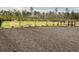 Expansive backyard with gravel section fenced-in grassy area, accented by freshly planted shrubs and bordering trees at 621 Woodside Dr., Conway, SC 29526