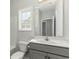 Well-lit bathroom featuring a toilet, sink, mirror, and window with natural light at 621 Woodside Dr., Conway, SC 29526