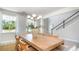 Bright dining room features a large table and a modern light fixture, illuminated by natural light from large windows at 7006 Shooting Star Way, Myrtle Beach, SC 29579