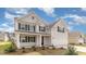 Attractive two-story home featuring gray siding, black shutters, and a welcoming front porch at 7011 Shooting Star Way, Myrtle Beach, SC 29579