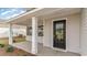 A covered front porch with white columns leads to a black front door with glass panel at 7011 Shooting Star Way, Myrtle Beach, SC 29579