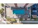 Overhead view of a well-maintained outdoor pool with a hot tub, tables, palm trees, and neatly arranged parking at 7509 N Ocean Blvd. # 1203, Myrtle Beach, SC 29572