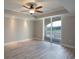 Bright, empty bedroom with wood floors, ceiling fan, and sliding glass door to balcony at 9547 Edgerton Dr. # 204, Myrtle Beach, SC 29572